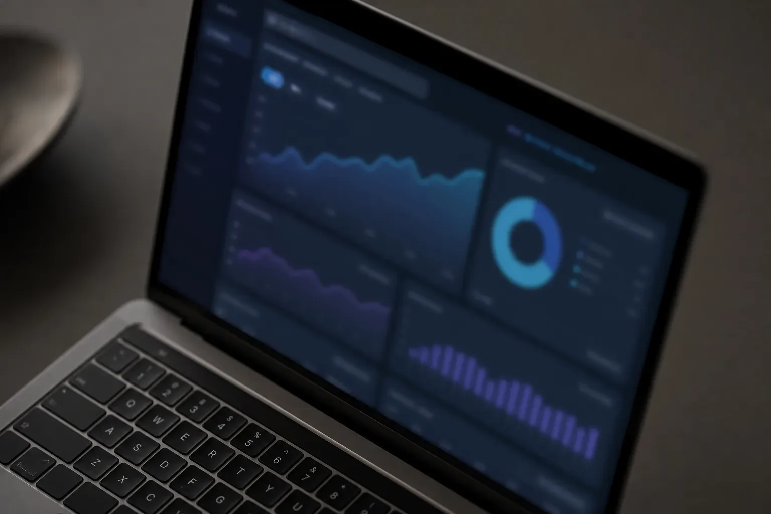 A half-open laptop with a blurred analytics interface glowing on its screen on a clear work surface, shot as a close-up detail overhead in soft diffuse lighting, the screen showing abstract session-duration and bounce-rate panels for a law firm site, the laptop hinge and keyboard edge framing the glowing display, no person in frame.